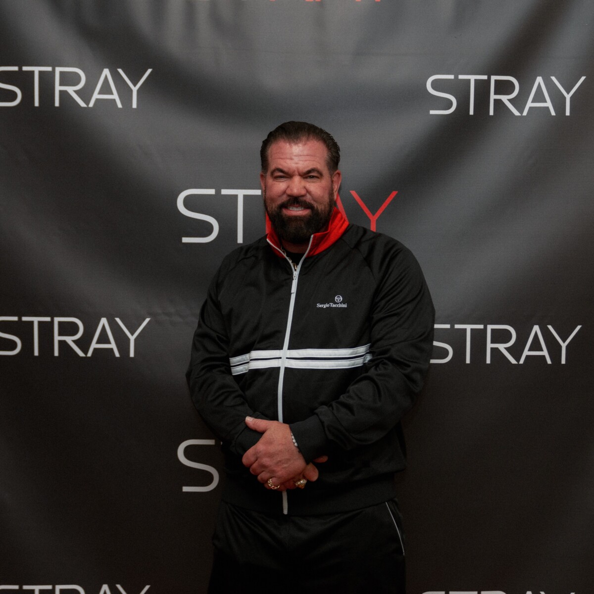actor bruce soscia posting for a photo at the stray movie announcement event